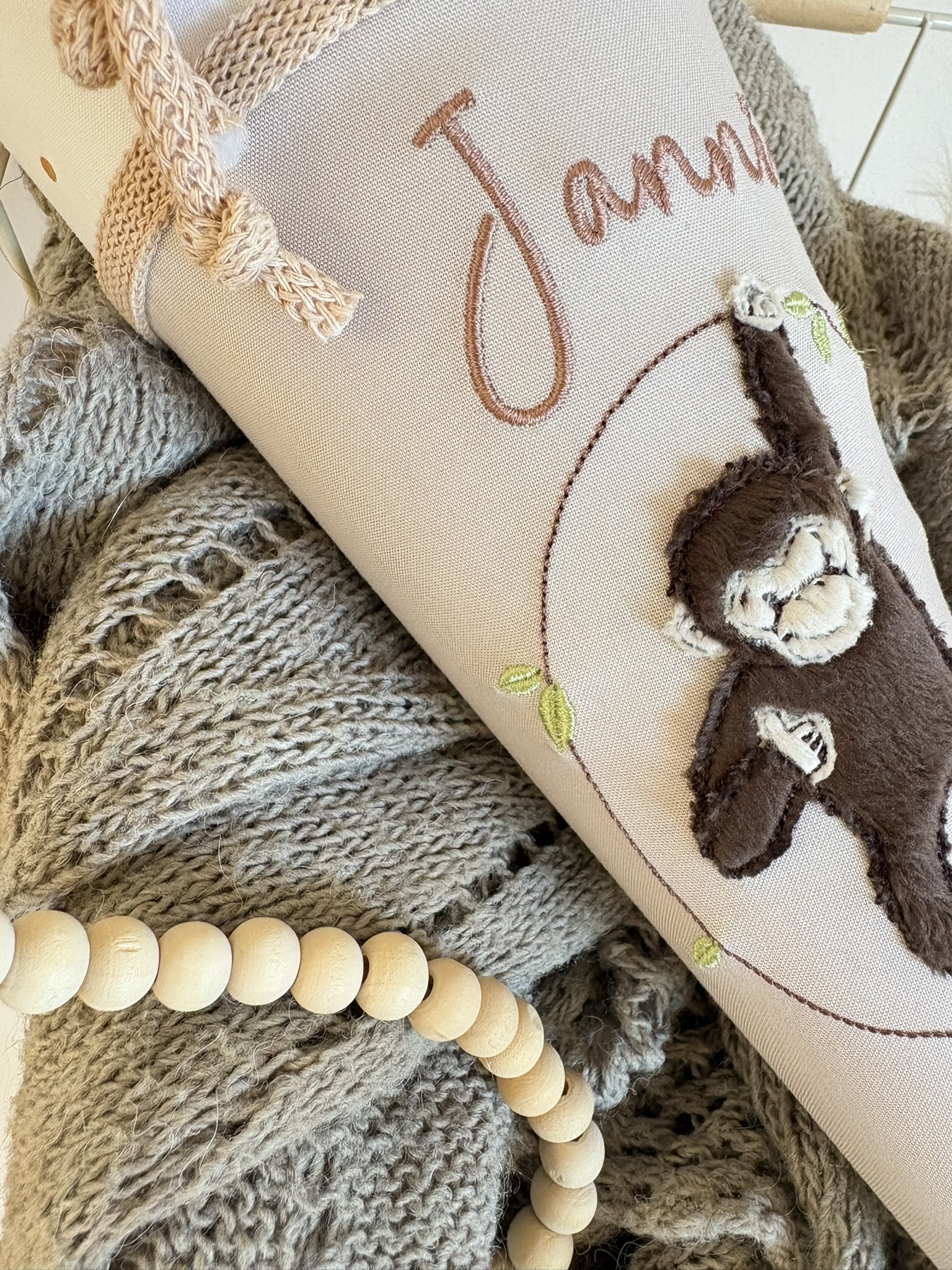 Detailansicht Affe an der Liane und Namensstickerei auf taupefarbener Kindergartentüte