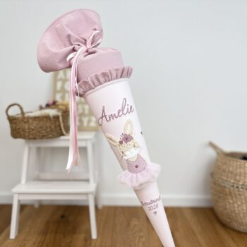 Schultüte Hasen-Ballerina altrosa vor Buchstabentafel und Körben