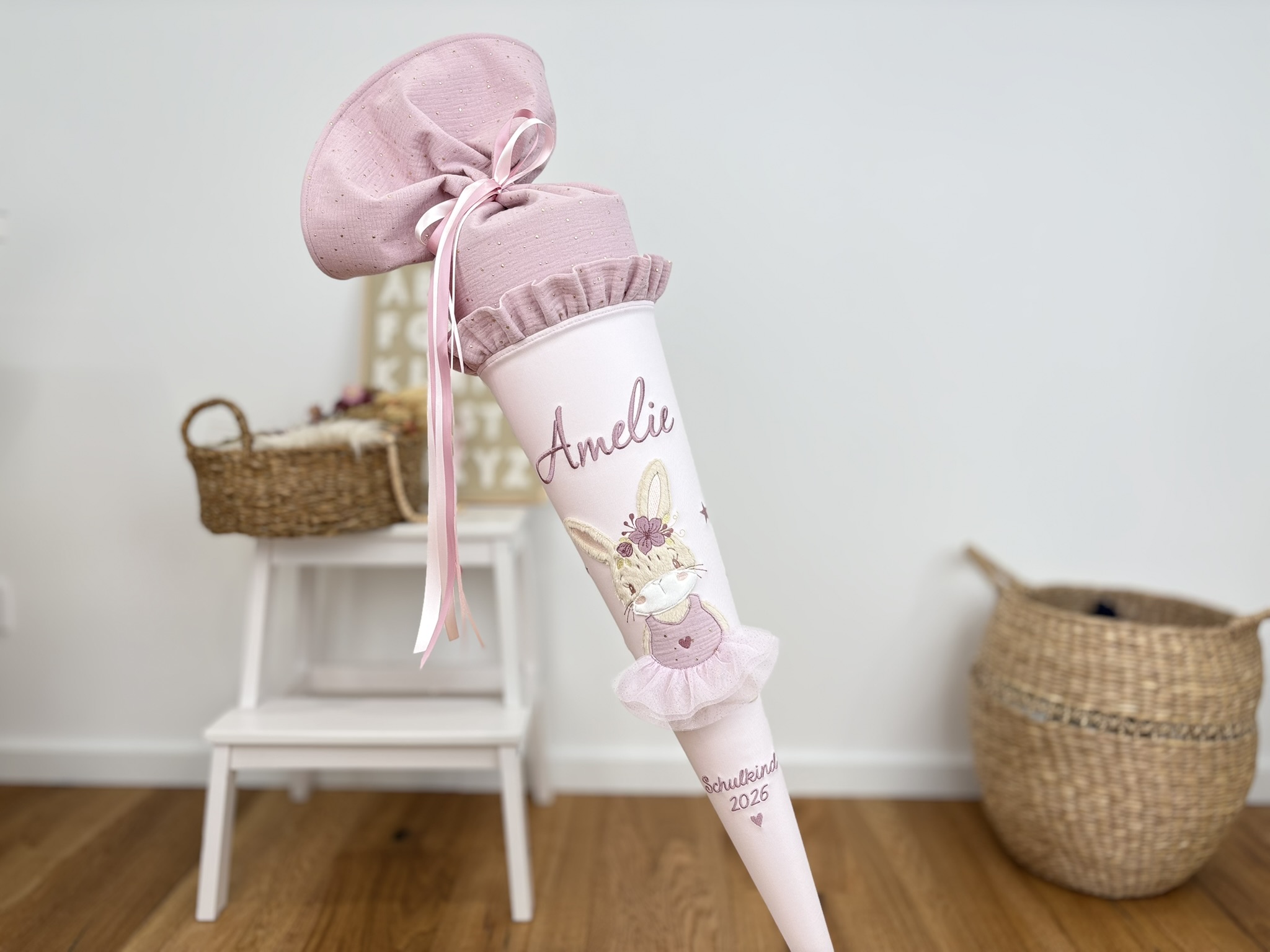 Schultüte Hasen-Ballerina altrosa vor Buchstabentafel und Körben